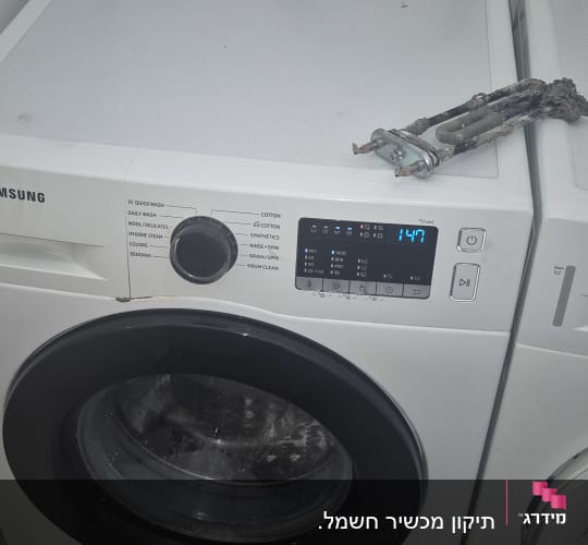 מכונת כביסה עם חלקי חילוף על גבי המכונה